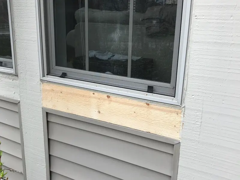 Window above vinyl siding with new wood framing below the sill