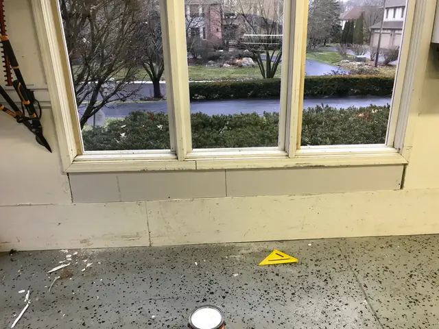 Three-pane window with tools and debris on the floor during installation