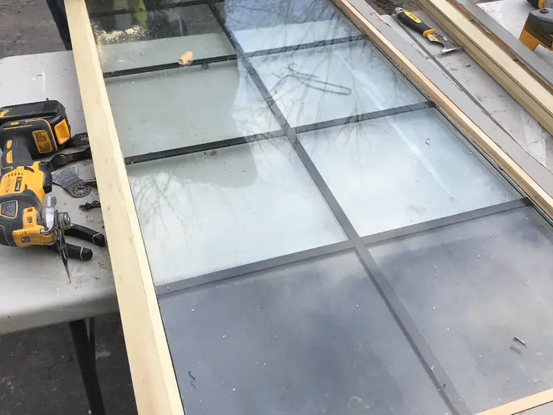 Window sash with grids laid on a work table for repair
