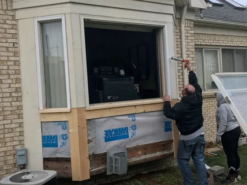 Bay window being installed on a brick home